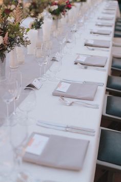 a long table is set with place settings and silverware for an elegant wedding reception