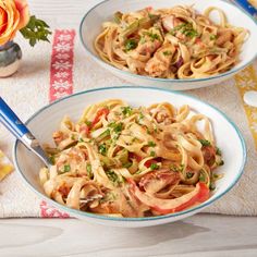 two bowls filled with pasta and meat on top of a table