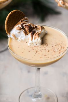 a drink with whipped cream and a cookie on top