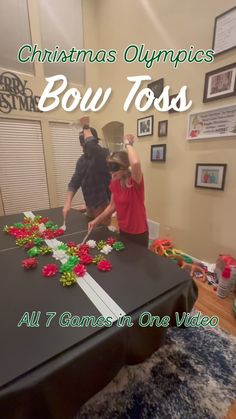 two people standing at a table with decorations on it and the words christmas olympics bow toss