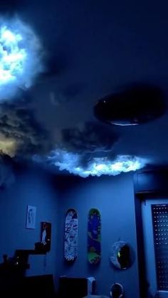 a room with skateboards on the ceiling and clouds in the sky above it at night