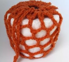 an orange and white crocheted object on a white surface