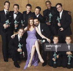 a group of men and women posing for a photo with their award winning trophies in front of them