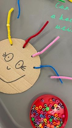 a child's craft with beads on it and a paper plate next to it