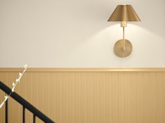 a lamp on the wall next to a stair case