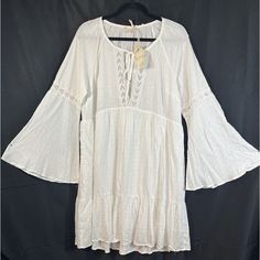 This Hem & Thread Dress Is A Stunning Addition To Any Wardrobe, Featuring A Beautiful White Color And Bohemian Style. The Dress Has A Large Size And Is Perfect For Any Occasion, Whether It's A Wedding, Party, Or Casual Outing. The Dress Is Made With High-Quality Rayon Material And Features A Crochet Fabric Type, With Accents Of Crochet, Layered And Embroidered Details. The Dress Has A Shift Style And A Short Length, With Long Bell Sleeves And A Tie Closure. It Also Features A Keyhole Neck And Pe Casual Bell Sleeve Beach Dresses, Casual Flowy Boho Dress With Lace Trim, White Lace Trim Tunic Dress, Casual Beach Dress With Bell Sleeves, Casual Beach Dresses With Bell Sleeves, Flowy Peasant Dress For The Beach, Flowy Peasant Dress For Beach, White Casual Peasant Dress For Spring, White Long Sleeve Summer Boho Dress