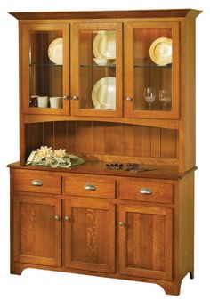 a wooden hutch with glass doors and plates on it's side, in front of an american flag