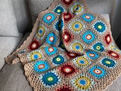 a crocheted granny blanket sitting on top of a couch