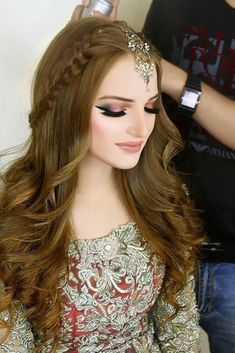 a woman with long hair is getting her make - up done