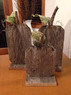 two wooden vases with plants in them sitting on a table