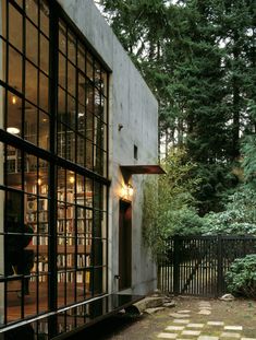 an image of the outside of a house that is lit up with lights and bookshelves