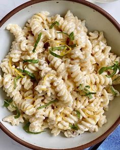 a white bowl filled with macaroni and cheese on top of a blue napkin