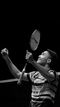 a man holding a tennis racquet on top of a tennis court with his arm in the air