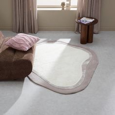 a living room with a large rug on the floor next to a chair and table