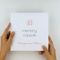 two hands holding up a card that says memory capsulee honeymoon edition on the front