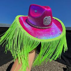 a woman's foot wearing a purple hat with green fringe