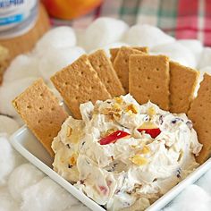 a white bowl filled with food next to crackers