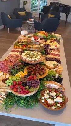 a long table filled with lots of food on top of a hard wood floored floor