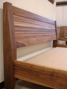 a wooden bed frame with no sheets on it