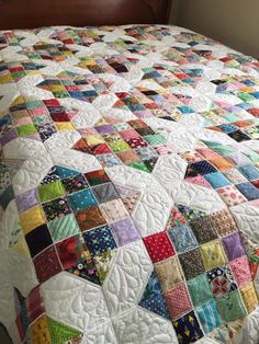 a bed with a colorful quilt on top of it