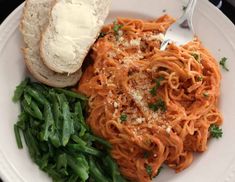 a white plate topped with pasta and bread