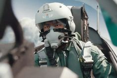 a man wearing a helmet and goggles in the cockpit of an airplane