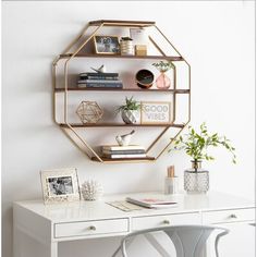 a white desk with a gold hexagonal shelf above it