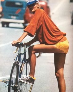 a woman riding a bike down a street