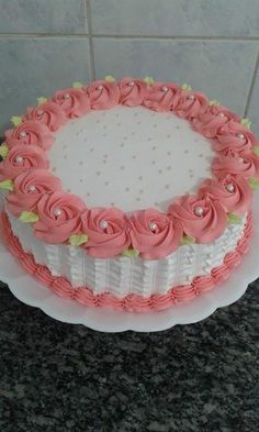 a white cake with pink frosting and flowers on it