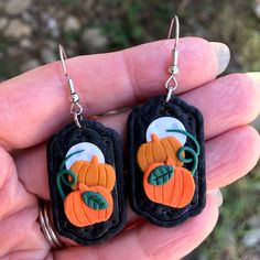 a pair of earrings with an image of a pumpkin on it