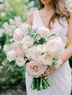 a woman holding a bouquet of white and pink flowers