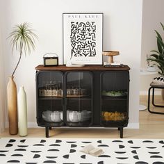 a living room with a black and white area rug, two vases and a painting on the wall