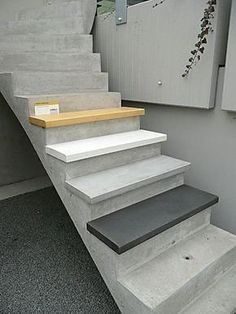 there is a set of concrete stairs leading up to the building's second floor