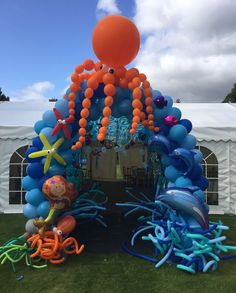 an under the sea balloon arch with octopus, starfish and dolphin balloons on it