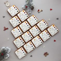 decorated cookies arranged in the shape of christmas trees with decorations around them on a table