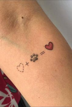 a woman's arm with a dog paw and heart tattoo on the left side