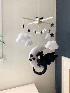 a black and white dragon mobile hanging from the ceiling in a child's room