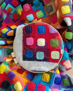 a colorful patchwork quilt on top of a multicolored blanket with an applique