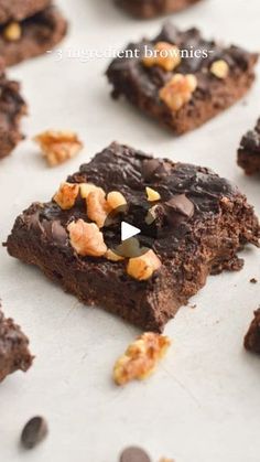 chocolate brownies with walnuts on top are sitting on a baking sheet and have been cut into squares