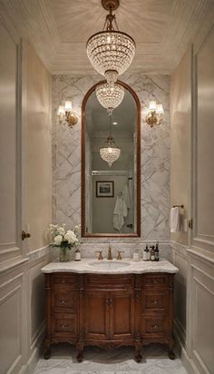 a fancy bathroom with chandelier and marble counter tops