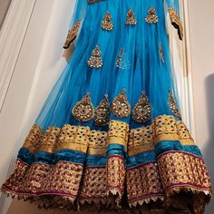 This Is An Amazing Blue Anarkali Dress With Matching Pants And Scarf. The Fabric Has Shining Gold Accents. This Will Make A Great Choice For Any Occasion. Blue Floor-length Dupatta With Dabka, Blue Churidar With Sheer Dupatta, Fitted Blue Churidar With Sheer Dupatta, Blue Dabka Anarkali Set For Party, Blue Sharara With Dabka For Navratri, Blue Dabka Sharara For Navratri, Blue Churidar With Sheer Dupatta For Navratri, Party Blue Churidar With Sheer Dupatta, Blue Dabka Dress For Designer Wear