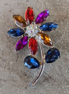 This listing is 1 Vintage Silver Stemmed Flower Brooch Pin. Please see the listed picture of the item you will get. We carry more Vintage Jewelry in many styles and colors. Check out our selection here: https://www.etsy.com/shop/AJStuff?section_id=29081334 Please contact us with any questions and thanks for visiting us. Vintage Flower Brooch Jewelry, Vintage Flower Brooches For Formal Occasions, Retro Flower Brooches For Collectors, Vintage Flower-shaped Jewelry With Rhinestones, Blue Flower-shaped Jewelry Brooch, Flower Tops, Flower Brooch, Lapel Pins, Vintage Brooches