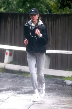 a woman running in the rain wearing headphones