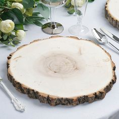 the table is set with white flowers and silverware