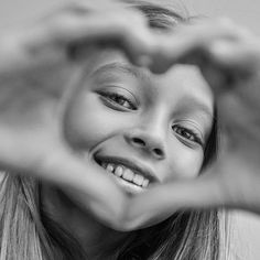 a woman making a heart shape with her hands