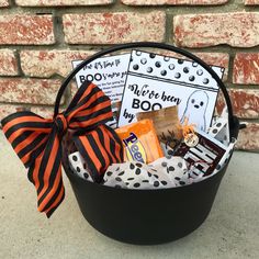 a trick or treat basket with candy, candies and halloween decorations in front of a brick wall