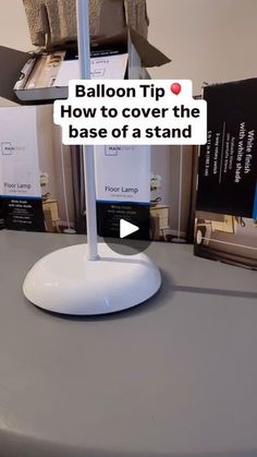 a table with a sign that says balloon tip how to cover the base of a stand