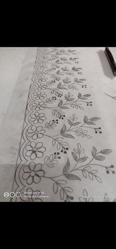 the table is covered with an intricately designed white cloth and has black flowers on it