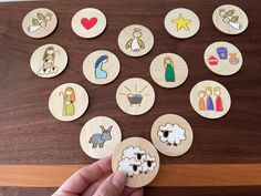 a person is holding some wooden magnets on a table