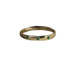 An organic flat band with golden emerald detail. A colorful, dainty piece meant to be worn daily as a symbol of the beauty in the imperfect. ~ hand dripped + carved by Rosalie ~ solid 14k recycled gold ~ 1.5 mm round emeralds ~ for custom size, please send a note with your order ~ made to order, please allow up to 4-6 weeks to ship Everyday Emerald Ring In Yellow Gold, Stackable Yellow Gold Emerald Ring For Promise, Yellow Gold Stackable Emerald Ring For Promise, Everyday Green 14k Gold Stackable Rings, Yellow Gold Emerald Stackable Rings With Round Band, Everyday Stackable Emerald Ring In Yellow Gold, Everyday Yellow Gold Emerald Ring, Everyday Gold Emerald Ring, Dainty Yellow Gold Stackable Emerald Ring